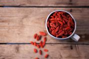 Goji-Beeren in einer Tasse auf einem Holztisch. Goji-Beeren in einer Tasse auf einem Holztisch.